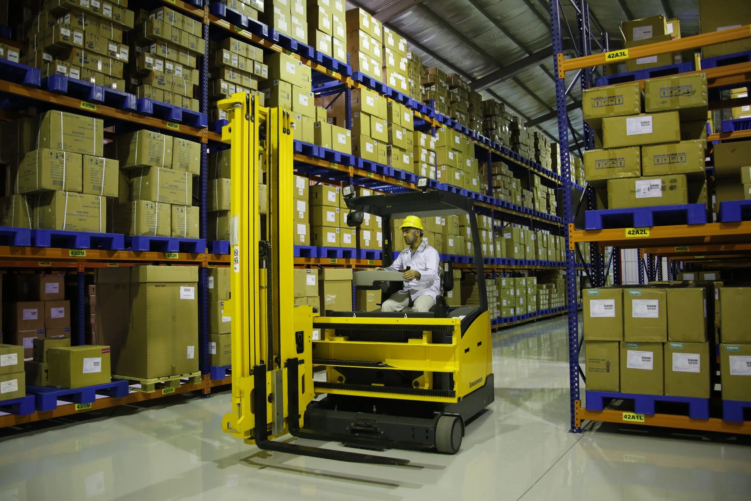Forklift operator moving pallets in a Kawkab warehouse